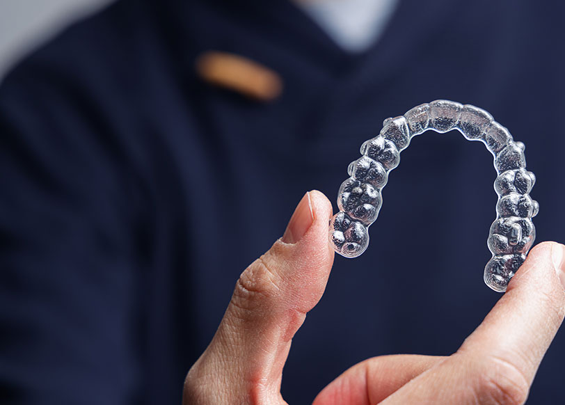A dentist holding clear aligners